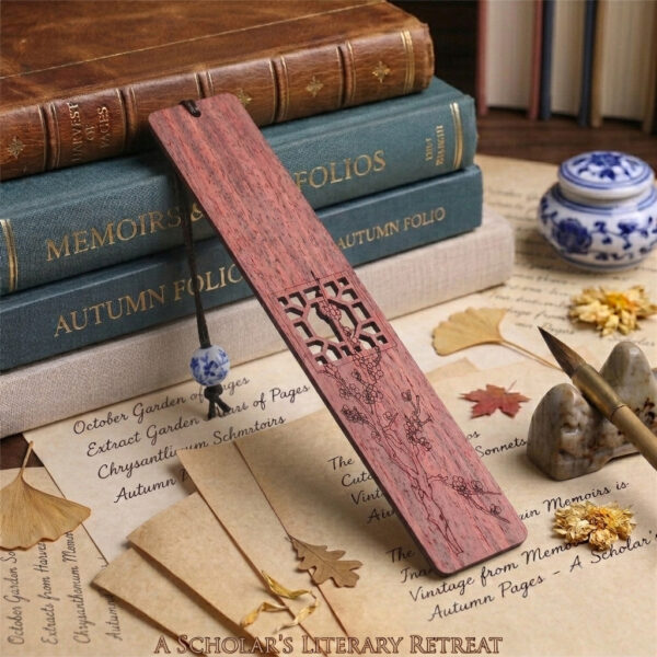 Redwood plum blossom bookmark displayed against vintage stack of books and ancient letters with porcelain bead accent.