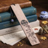 Light wood bookmark with detailed chrysanthemum carving resting on old manuscript pages and stacked antique books.
