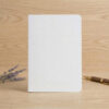 A5 notebook refill insert with white soft cover on wooden desk with fountain pen