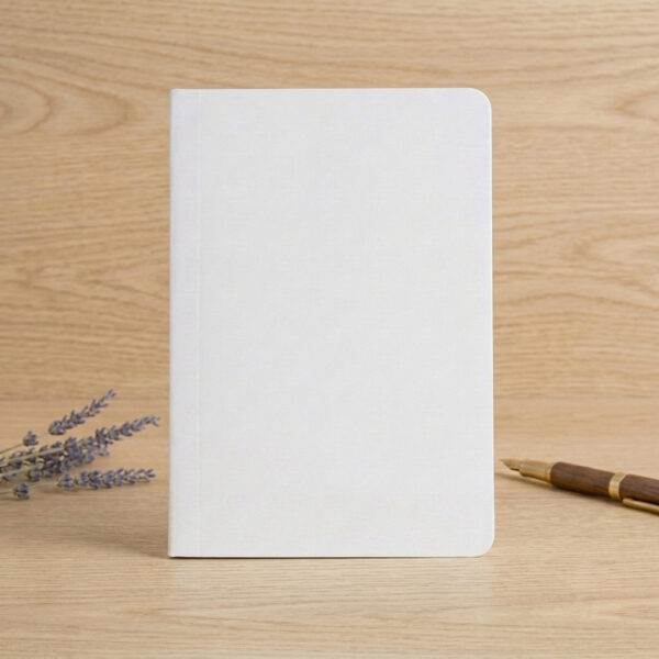 A5 notebook refill insert with white soft cover on wooden desk with fountain pen